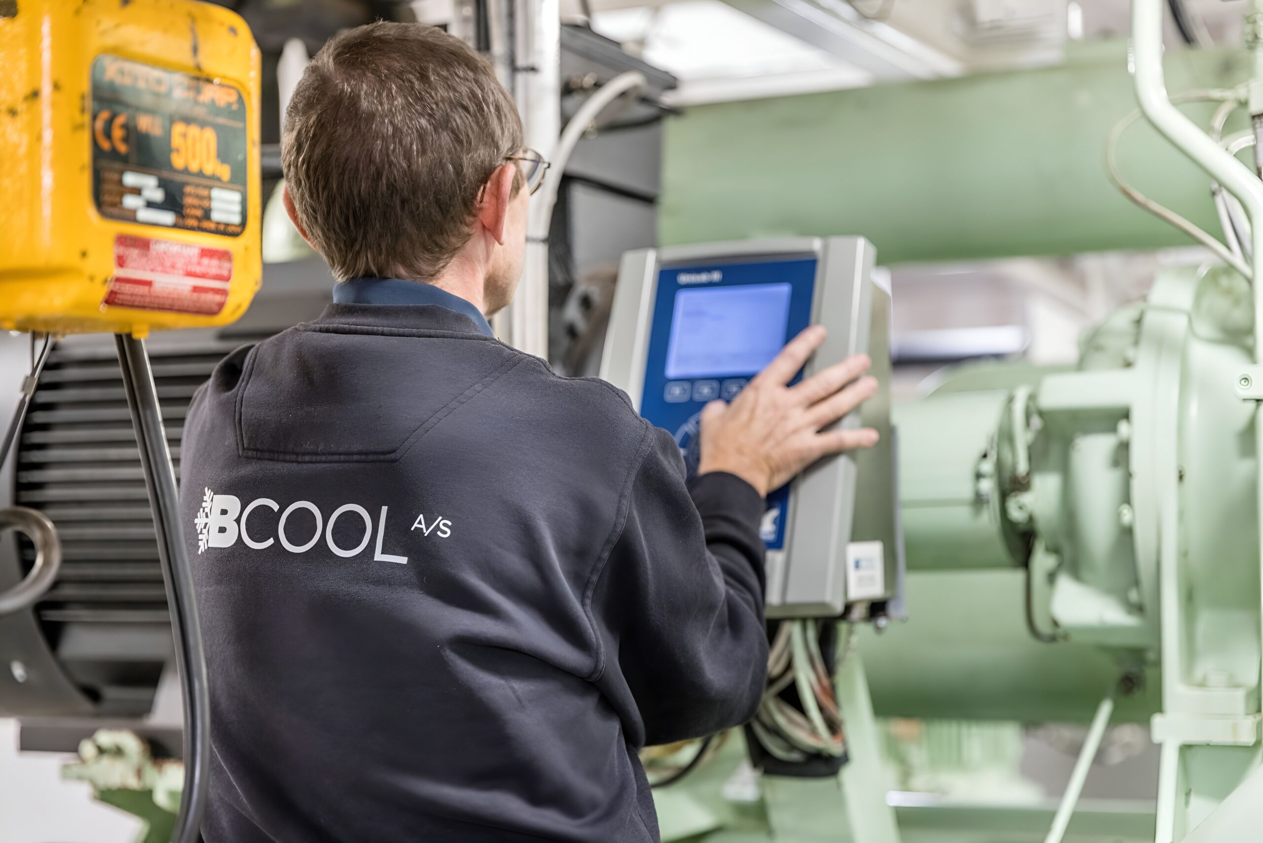 BCOOL A/S tekniker arbejder med køleanlæg og styringssystem som del af AI-automatisering af tilbudsprocesser udviklet af WeZimplify.